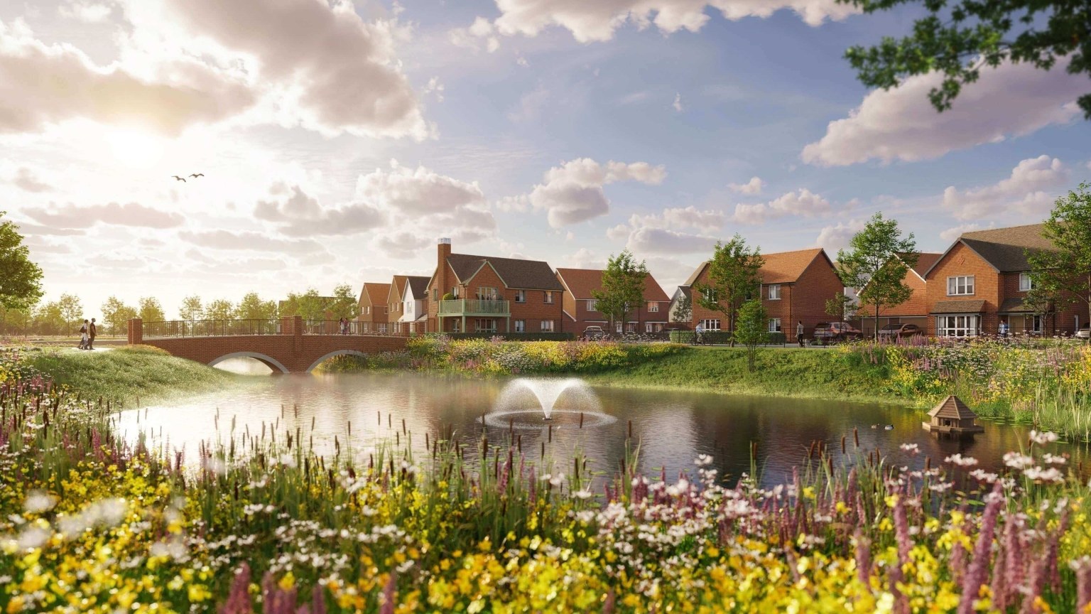 A pond with a fountain, a bridge and wildflowers at Eastbrook Village, Milton Keynes