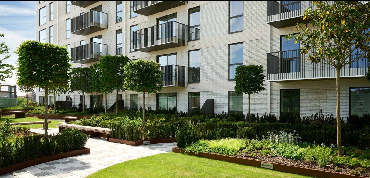 A landscaped communal garden with trees and benches at Silkstream, Hendon